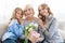 Women generation. Granny with presents, mom and daughter hugging grandmother