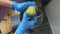 A women gloved hands peel potatoes with a knife