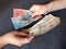 women hands exchanging Australian banknotes and American dollar money