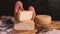 Women hands showing fresh homemade cheese on a wooden board with a cheese knife close up