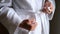 Women hands tying belt on white bathrobe closeup