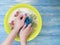 Women hands are washed holding in a basin on a blue on a wooden background