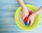 Women hands are washed holding foam service in a basin on a blue on a wooden background