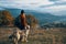 women hikers next to dog walk mountains autumn forest