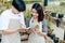 Women hold cactus and a man writing note in a book. Love couple enjoy hobby with darden cactus