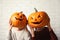 Women holding Halloween pumpkin head jack lanterns