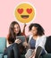 Women holding a heart eyes emoticon and using a tablet