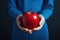 Women holding a red apple in his hand. closeup, blue dress, hand and apple in focus
