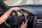 A women holds the steering wheel,in the black salon automobile,in windouws the view on a white lines