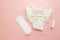 Women intimate hygiene products - sanitary pads and tampon near womans panties on pink background