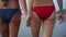 Women lesbian girlfriends walk along the beach in bikini swimsuits. LGBT concept