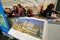 Women look at new art books at the indoor book fair