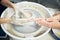 Women making ceramic pottery, concept for workshop and master class, four hands close-up, focus on potters, palms with pottery.