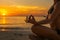 Women meditation on the ocean beach at sunset