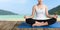 Women meditation yoga on wood balcony beach