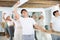 Women and men training in ballet class with other dancers in studio