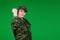 Women in military clothes show fist to the camera. Green background and empty space to advertisment
