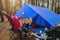 Women Nature tourism, camping in the middle of the pine forest. Sitting and eat food in front of the tent