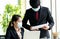 Women in the office wear mask and listening her boss to inform on the progress of work