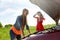 Women with open hood of broken car at countryside