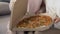 Women opening cardboard box with fresh flavored pizza, food delivery service