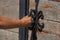 Women opens an ancient wooden door decorated with wrought iron elements