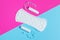 Women pads and tampon - sanitary pads lies next to a tampon on an isolated background on a pink and blue background