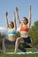 Women Performing Yoga Exercises In Park