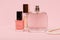 Women perfumes and cosmetics on a pink background