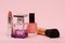 Women perfumes and cosmetics on a pink background