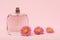 Women perfumes with flowers on a pink background