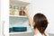 Women picking an item from storage hutch. Smart kitchen organization concept