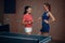 Women play doubles table tennis, ping pong players