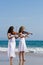 Women play violin on beach