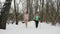 Women practice Nordic walking in a snowy forest