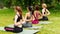 Women practicing yoga with namaste behind their backs at park, empty space