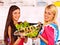 Women prepare fish in oven.