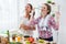 Women preparing healthy food playing with vegetables in kitchen having fun concept dieting nutrition