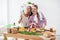 Women preparing healthy food playing with vegetables in kitchen having fun concept dieting nutrition