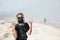 Women in protective filter mask walking around Ijen volcano crater