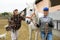 Women ranchers preparing white horse for ride