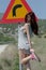 Women in rear view wear hot clothes pose front of a traffic sign danger turn