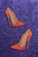 Women red shoes with glitter on a purple glittery background