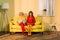 women in retro clothing reading books sitting on yellow sofa at bright apartment doll