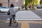 Women ride a bicycle on the footpath and waiting traffic light for cross the road