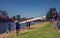 The women rowing team prepare to start with their boat on the bank of Yarra river