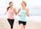 Women running jogging training happy on beach