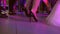 Women's beautiful legs in black high-heeled shoes dance on the dance floor in the club. feet dance in heels