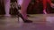 Women's beautiful legs in black high-heeled shoes dance on the dance floor in the club. feet dance in heels
