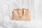 Women`s beige bag on white background from a soft material. spring fashion concept